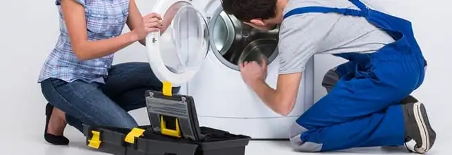 Washer repair technician inspecting a front-load washing machine with tools in Riverside, CA
