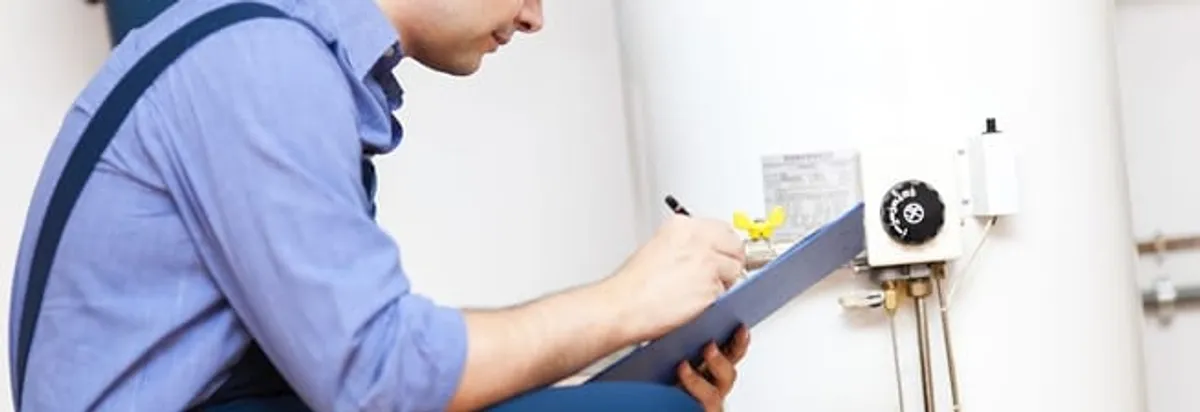 Water heater repair technician inspecting the unit and recording service notes in Riverside, CA