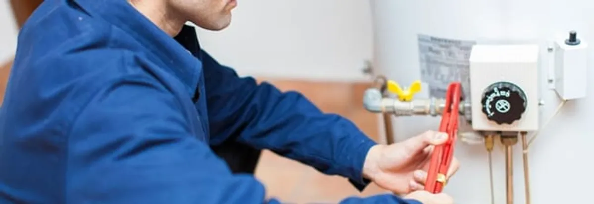 Water heater repair technician adjusting the temperature control and gas valve in Riverside, CA